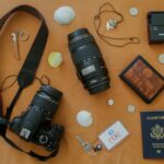 Canon black DLSR camera with lens, keys, wallet, charger and passport