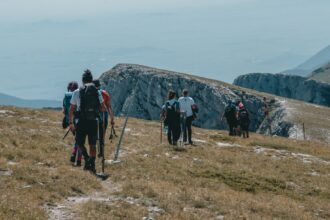 Detailaufnahme eines professionell gepackten Trekking-Rucksacks mit ordentlich verstauten, hochwertigen Gadgets wie wasserdichter Packtaschen, kompakter Filterflasche, Powerbank und Stirnlampe.