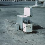 Kühlbox mit Kompressortechnik für den mobilen Einsatz, befüllt mit Eiswürfeln und Getränkedosen im Freien.