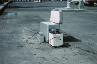 Kühlbox mit Kompressortechnik für den mobilen Einsatz, befüllt mit Eiswürfeln und Getränkedosen im Freien.