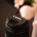 Rosa Canon Zoemini 2 Sofortbildkamera neben 20 Bögen Fotopapier, kompaktes Reise-Gadget für Urlaubsfotos.