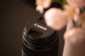 Rosa Canon Zoemini 2 Sofortbildkamera neben 20 Bögen Fotopapier, kompaktes Reise-Gadget für Urlaubsfotos.