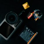 Die DJI Osmo Action 5 Pro Kamera vor heller Nachtkulisse – perfekt für klare Reisevideos bei Dunkelheit.